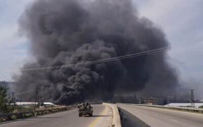 Photo: The smoke rises while the members of the Syrian forces travel in a vehicle in Latakia